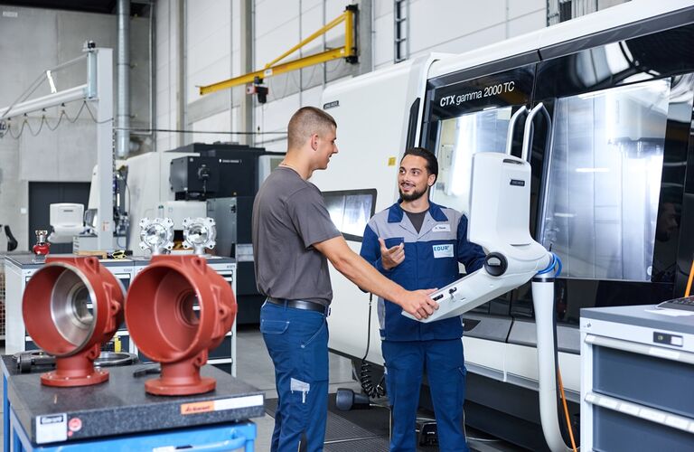 EDUR Mitarbeitende in der Zerspanung an einer CNC Maschine